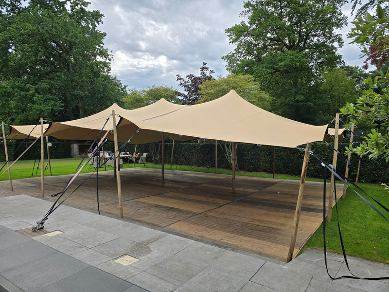 Witte partytent opgebouwd op een grasveld tijdens een evenement